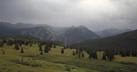 Aerial flying through pine trees in a high mountain pass with rainy weather Stock Footage 113876119