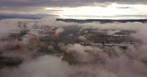 Aerial: Flying through red and green canyon in cloudy mists Stock Footage 101900300