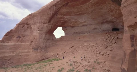 Aerial flying through window in a giant sandstone rock in the desert Stock Footage 111361239