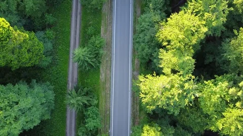 Aerial flying tilted down over modern and straight highway showing dark grey Stock Footage 76751408