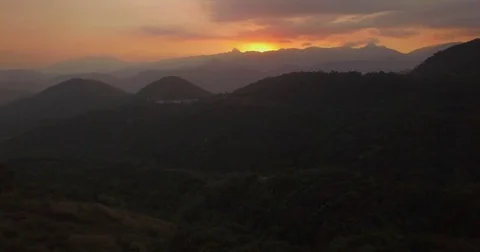 Aerial flying towards mountain sunset through the forest Stock-Footage 80965699