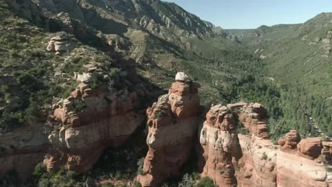 Aerial flying towards red cliffs in forested canyon landscape in Sedona, Arizona Stock Footage 211202745