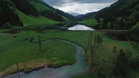 Aerial Flyover from Alpine Stream and Forest to Center of Glassy Mountain Lake Stock Footage 336806251