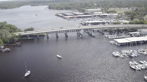 Aerial Flyover of a Bridge with Marinas on the Side of a River Video stock 65377286