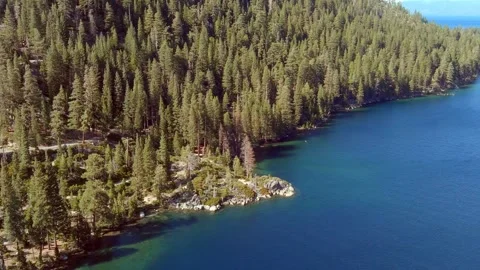 Aerial flyover of forest and cliffs along the shore of Lake Tahoe, California. Stock Footage 311818289