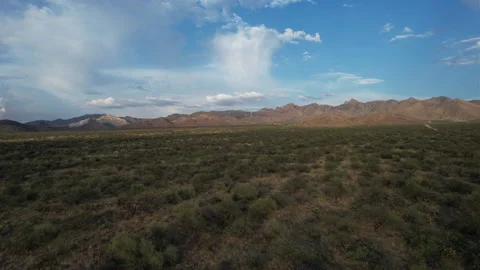 Aerial flyover of the high desert with a distant mountain range Stock Footage 197559472