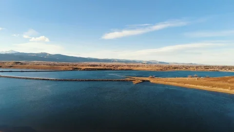 Aerial Flyover of a Reservoir and Rocky Mountains at Sunset - Color Graded Stock Footage