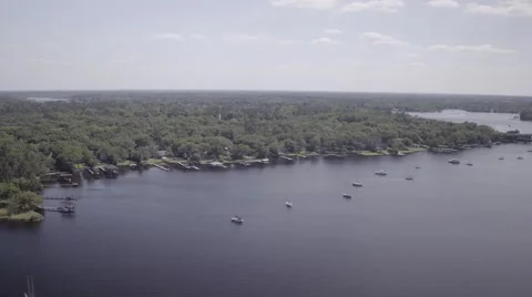 Aerial Flyover of River with Sparse Anchored Boats Video stock 65377314