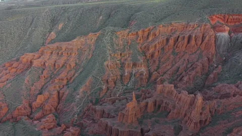 Aerial flyover shot over layered red sandstone cliffs and rugged eroded gorges Stock Footage 346505320