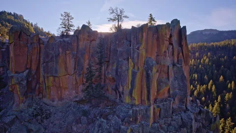 Aerial flyover of steep cliffs and tree clusters in arid New Mexico terrain 스톡 동영상 332621462
