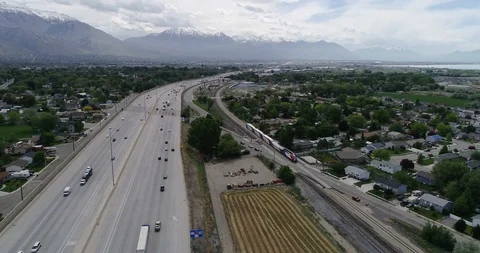 Aerial Flyover of Train and I-15 Freeway along Wasatch Front Corridor Stock-Footage 100696704