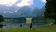 Aerial - Flyover Young Female Hiker Arriving To The Lake In The Alpine Mountains Stock Footage