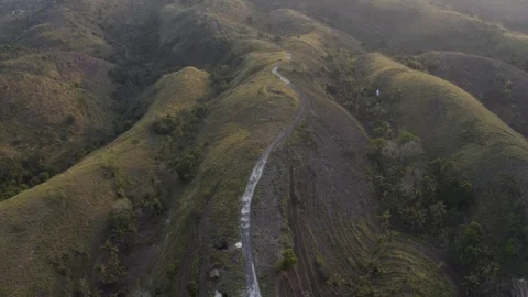 Aerial following a dirt track road in rural hills of Indonesia 4K Drone Clip Stock Footage