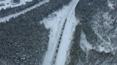 Aerial following shot of suburban electric train rides on the countryside on a Stock Footage