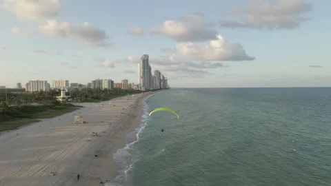 Aerial follows acrobatic paramotor flight over Haulover Beach, Miami Stock Footage 167985840