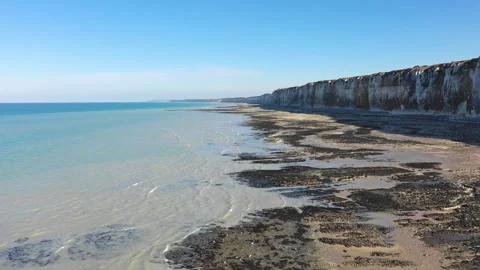 Aerial footage capturing the dramatic chalk cliffs and expansive beach at low 動画素材 346668570