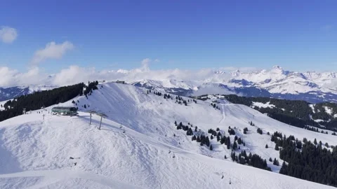 Aerial footage capturing a panoramic view of snow-covered ski slopes and a Stock Footage 346665099