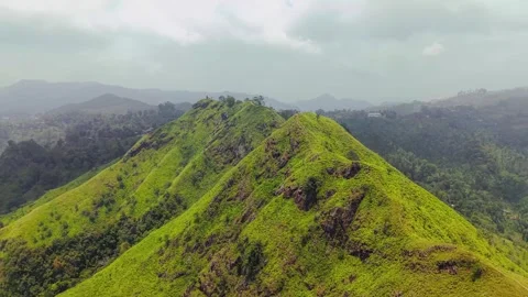 Aerial footage of dramatic green mountain ridge stretching through lush tropical Stock Footage 345482848
