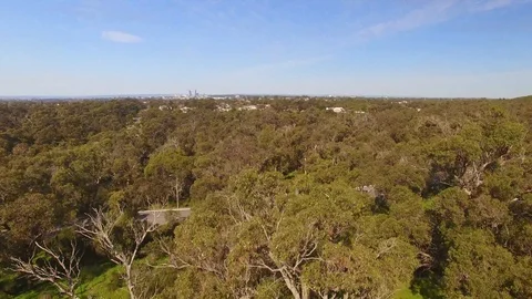 Aerial footage flying over a field then ascending to reveal and the city Stock Footage