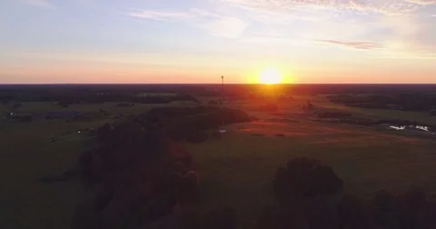 Aerial footage. Flying over the fields and forest at sunset with the sun's rays. Stock Footage
