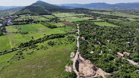 Aerial footage of mountain paths, fields, and houses Stock Footage 310475464