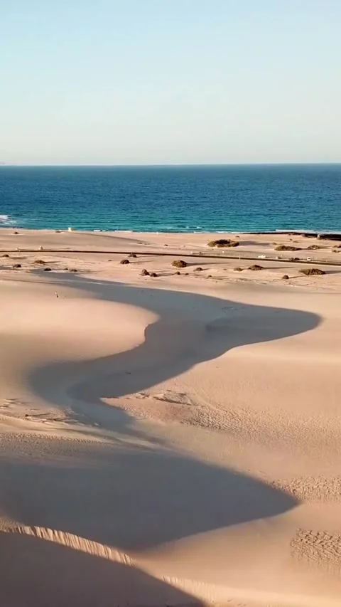 Aerial footage moving forward over a vast desert landscape with windswept sand Stock Footage 344839030