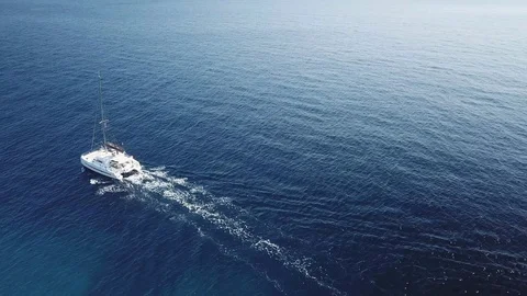 Aerial footage, pull back view of  Catamaran Sailboat sailing on a blue sea Stock Footage 96287298