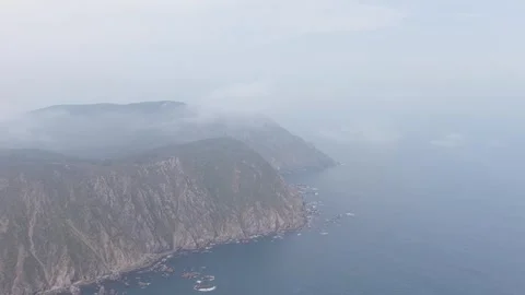 Aerial footage showcasing the dramatic rocky cliffs and rugged coastline of San Stock Footage 346703082