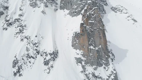 Aerial footage of side of structured mountain hill covered in snow going steep Stock Footage 121596362