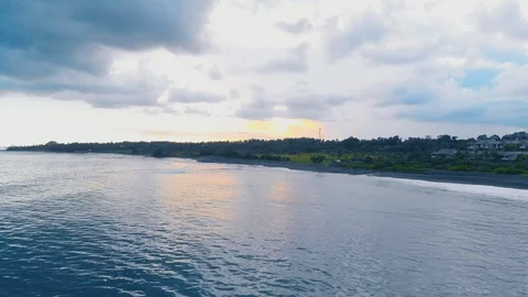 Aerial footage of sunset on beach with azure water, blue cloudy sky on Bali Stock Footage 87581372
