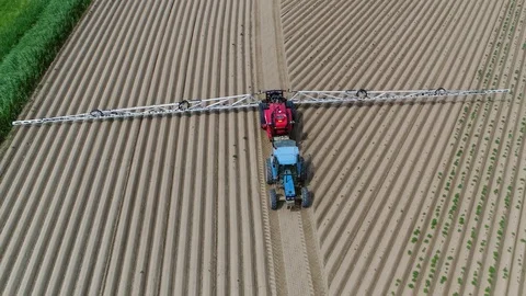 Aerial footage of tractor pulling a sprayer 4k Stock Footage 99045348