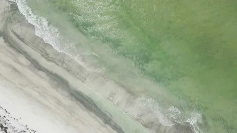 Aerial footage of turquoise waves crashing on a white sand beach Stock Footage