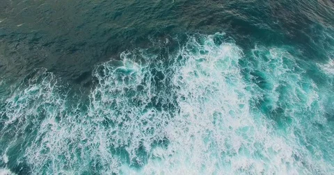 Aerial footage of white ocean waves. Top view of ocean waves and sunset. Drone Stock Footage