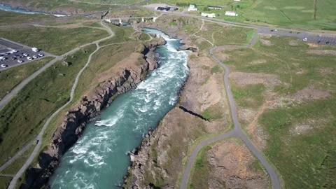 Aerial forward along river gorge to Godafoss waterfall and visitor area Stock Footage 346551965