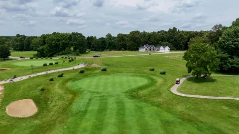 Aerial Forward Drone Shot of Golf Green and Remote Country Road Stock Footage 337637669