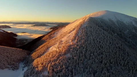 Aerial forward flight orbiting snow-capped mountain above cloud inversion Stock-Footage 322648613