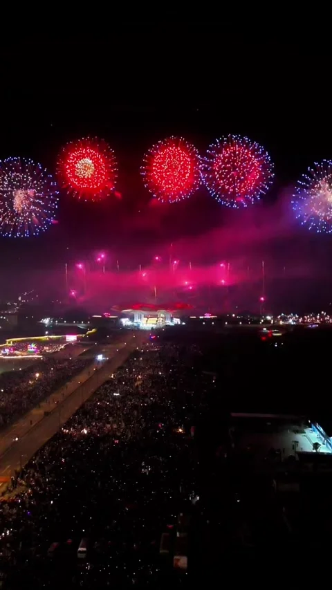 Aerial Forward Flight Over Massive Crowd Toward Distant Fireworks Display Stock-Footage 329007100