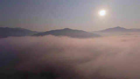 Aerial forward flight over thick sea of mist and mountain peaks 4K 스톡 동영상 334359358