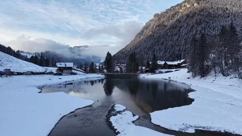 Aerial forward flight over a winter river flowing into a small dam reservoir 스톡 동영상 329505997