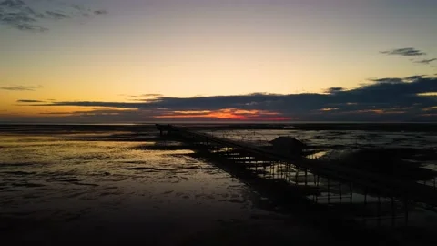 Aerial forward fly-over clip of Southport Pier at Sunset Merseyside England Stock Footage 197599622