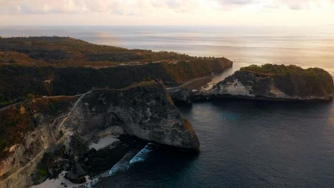 Aerial Forward of Grassy, Rocky Cliffs In Morning Light By Vast Ocean - Nusa Video stock 114083464