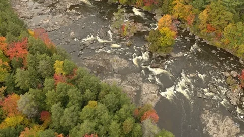 Aerial forward moving shot of river in fall creating whirls and rapids Stock Footage 119186985