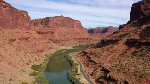 Aerial Forward Over Highway Passing By Colorado River In Canyon With Red Rocks Stockbeeldmateriaal 135311760