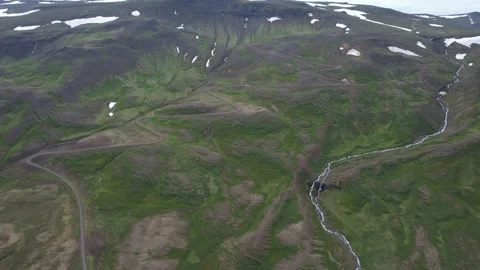 Aerial forward over mountainside gravel road and stream, Hellisheidi Eystri Stock Footage 346552053