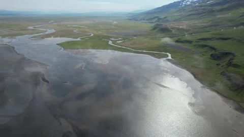 Aerial forward over river estuary with sky reflections, Hellisheidi Eystri Stock Footage 346552099