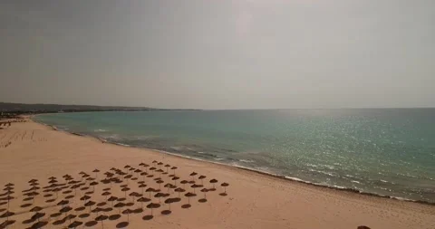 Aerial Forward Panning Beautiful View Of Parasols At Beach By Coastline On Sunny Stock Footage 185443881