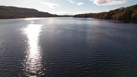 Aerial forward push over sparkling lake Coniston Water in Cumbria, England Stock Footage 336495453