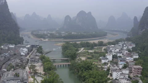 Aerial Forward: River and town amidst mountains - Xingping, China Stock Footage 149686129