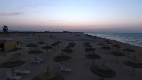 Aerial Forward Shot Of Deck Chairs Arranged Under Parasols At Beach During Stock Footage 185438254