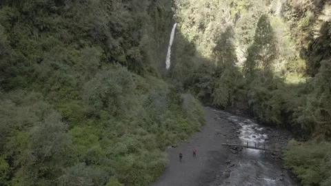 Aerial forward shot of a river surrounded by vegetation, with two people visible Stock Footage 249893602